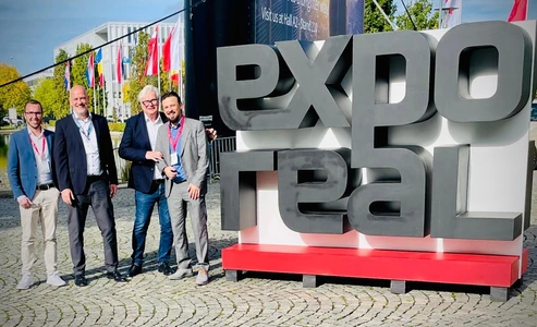 (v.l.n.r.) Steffen Blaser, Matthias Millow, Andreas Palla und John Frank neben dem Expo Real Logo
